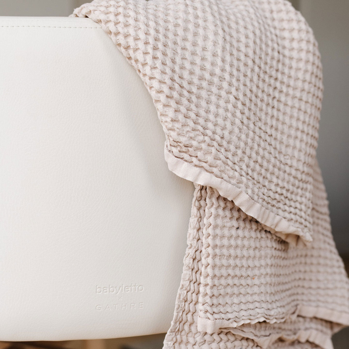 Blanket draped over Babyletto x GATHRE Capsule Bassinet - Ivory