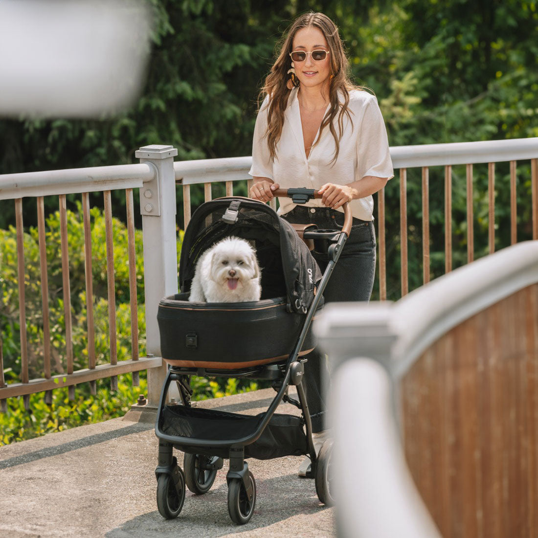 Woman pushing dog in Tavo Maeve Pet Car Seat - Medium Flex - Onyx