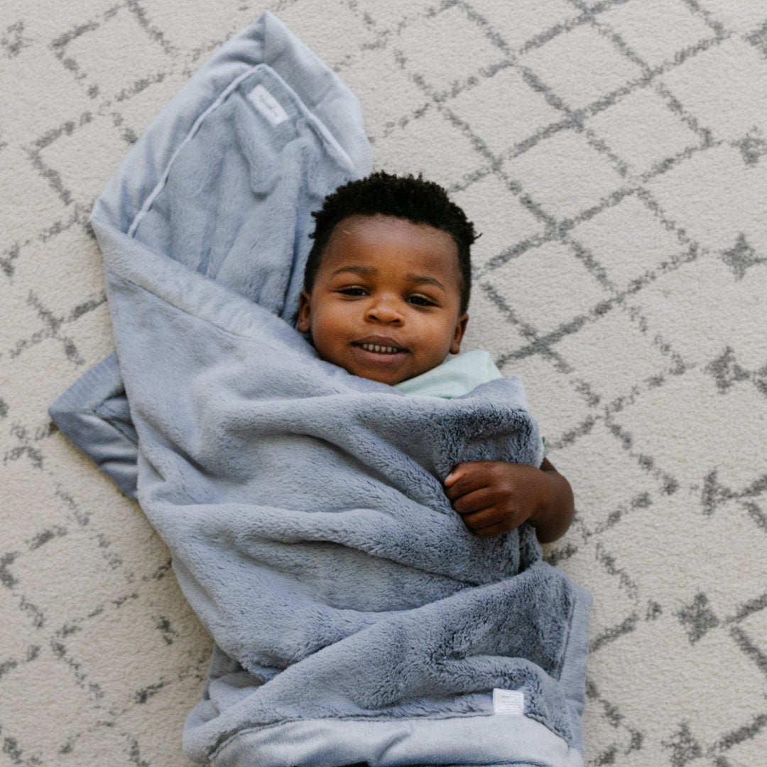 Little Boy laying in Saranoni Receiving Lush Blanket - Storm Cloud