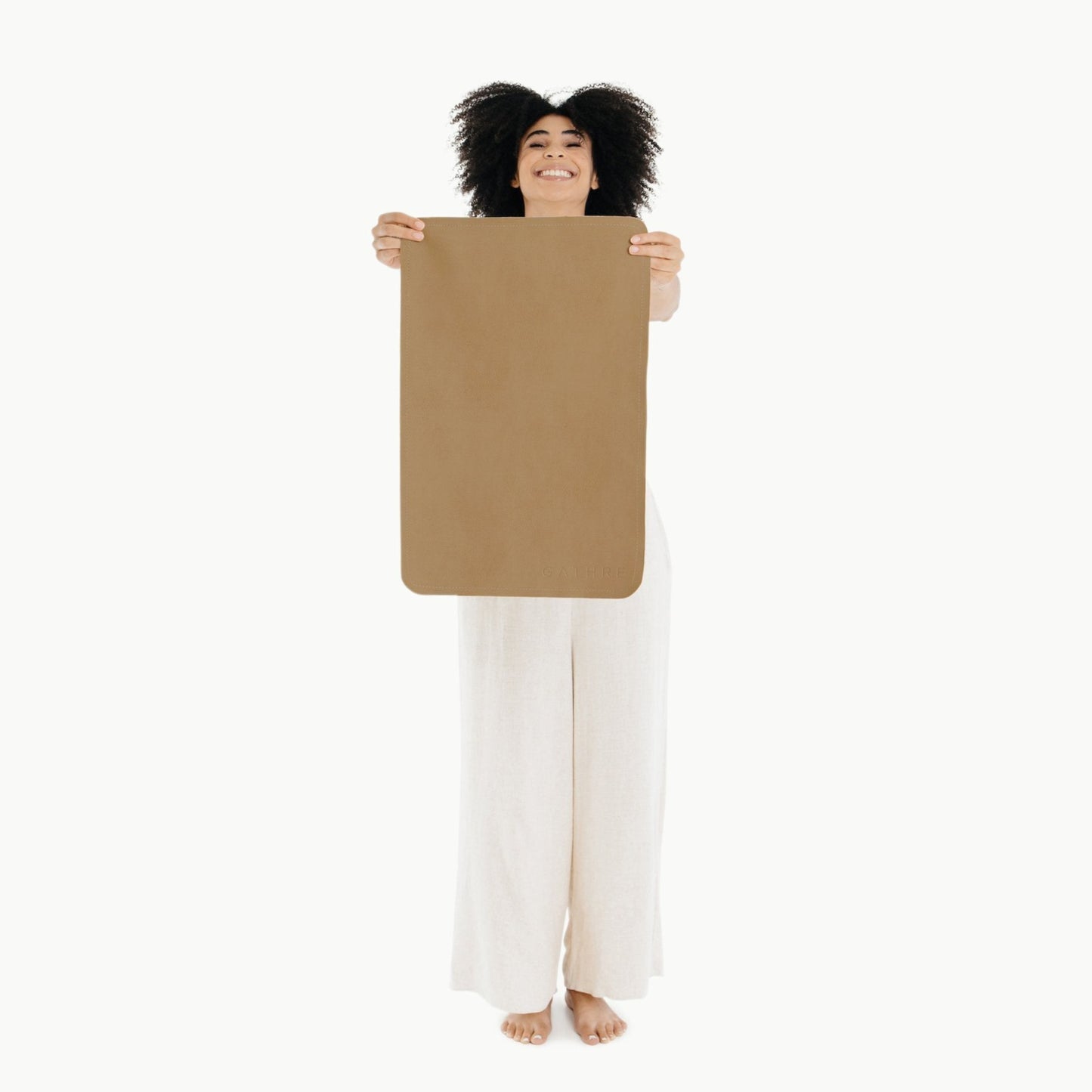 Woman holding up Gathre Micro Mat - Camel