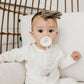 Baby sucks on pacifier attached to Copper Pearl Binky Clip Set - Bliss