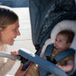 Mom smiles at baby sitting in Bumbleride 2024 Era Reversible Stroller - Ocean