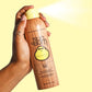 Adult spraying Sun Bum Original SPF 50 Sunscreen Spray