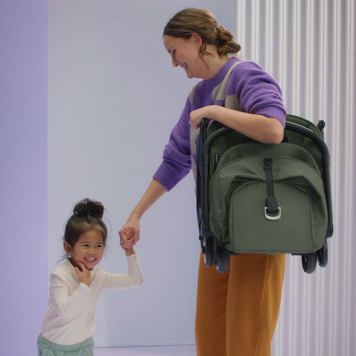 Woman carries Bugaboo Butterfly Complete Stroller