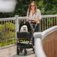 Woman pushing dog in Tavo Maeve Pet Car Seat - Medium Flex - Onyx