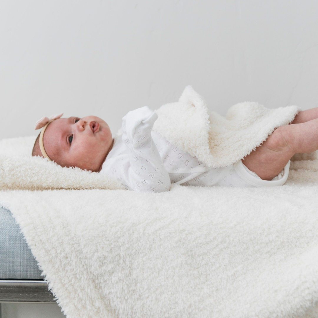 Baby laying on Saranoni Receiving Bamboni Blanket - Ivory