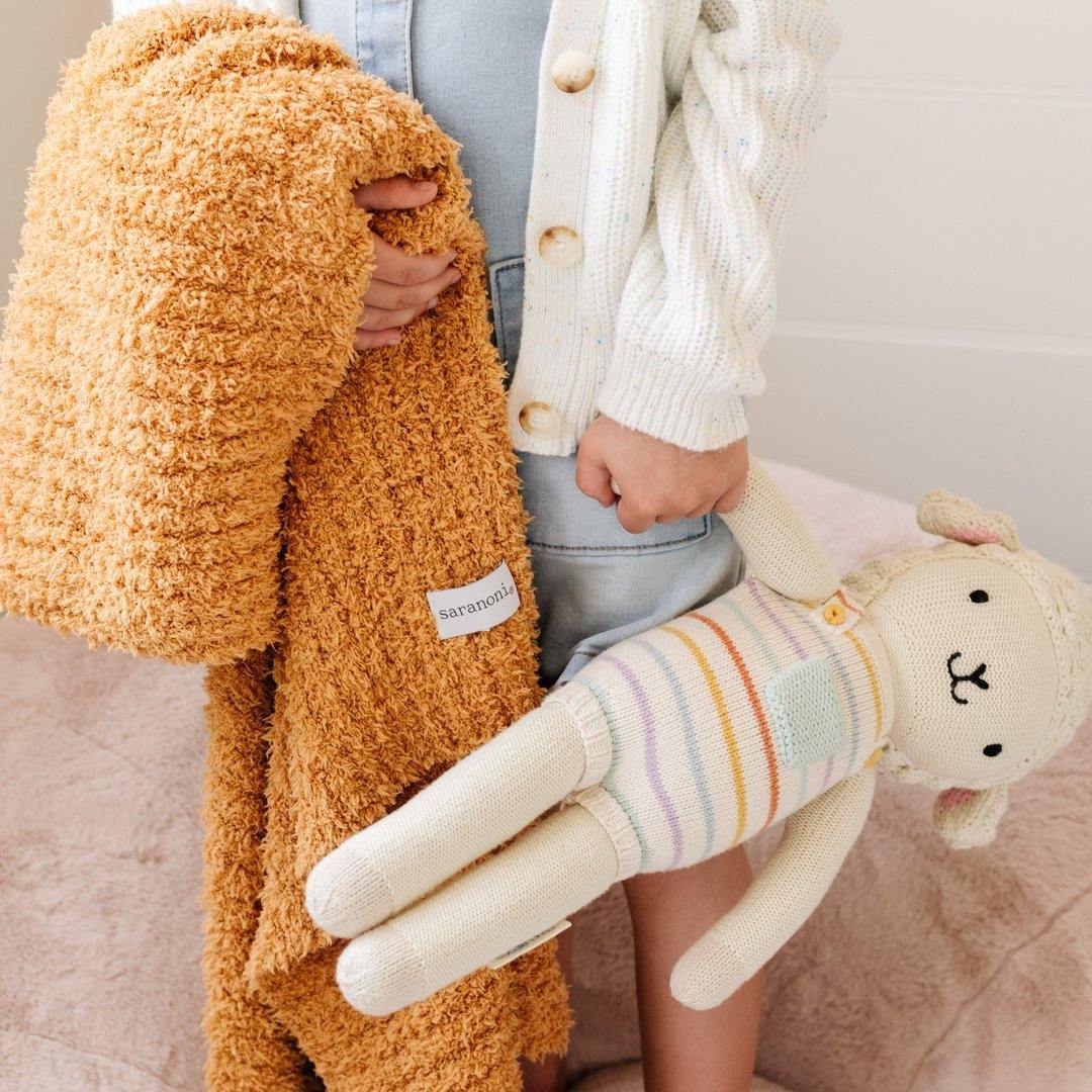 Child holding Saranoni Receiving Ribbed Bamboni Blanket - Golden