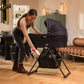 Woman placing baby items in basket of Nuna DEMI Grow Bassinet + Stand - Caviar