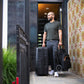 Man carries folded Nuna TRVL Stroller