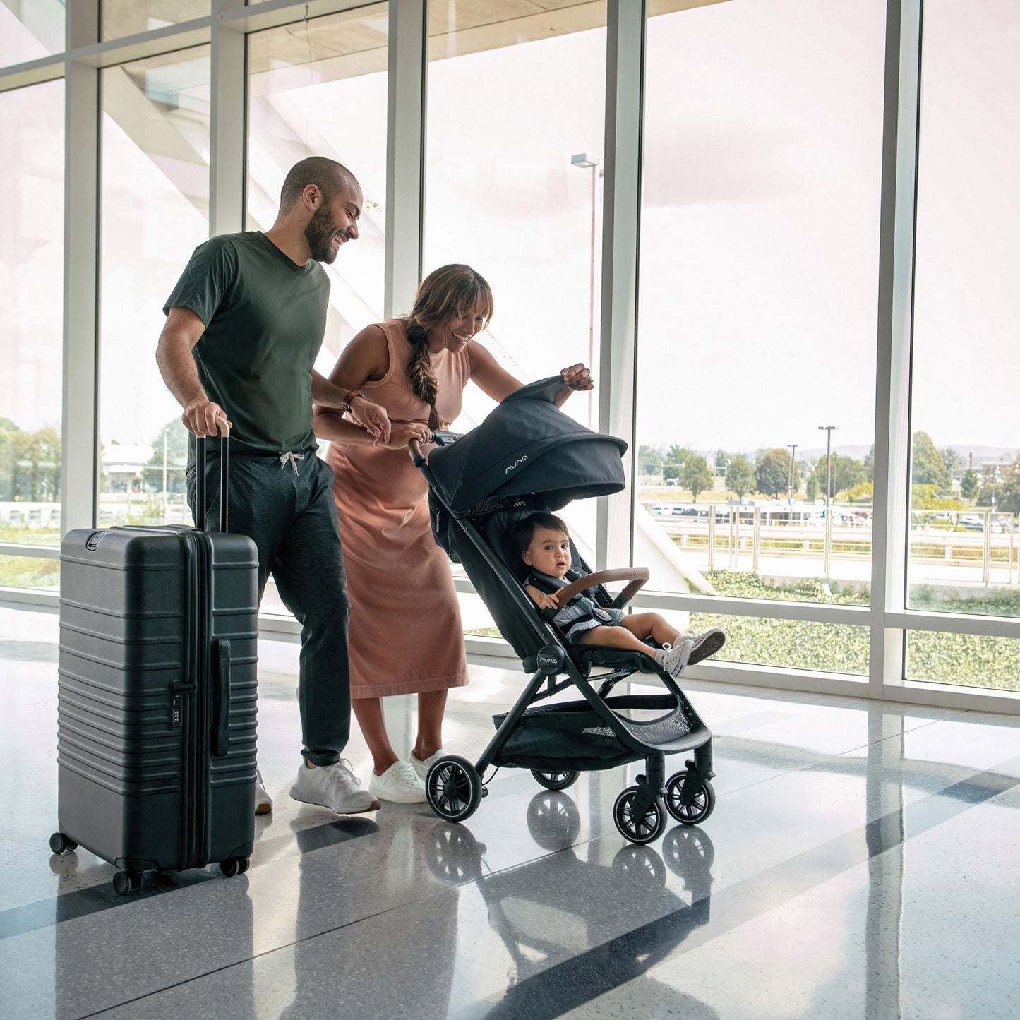 Couple pushes Nuna TRVL Stroller through airport