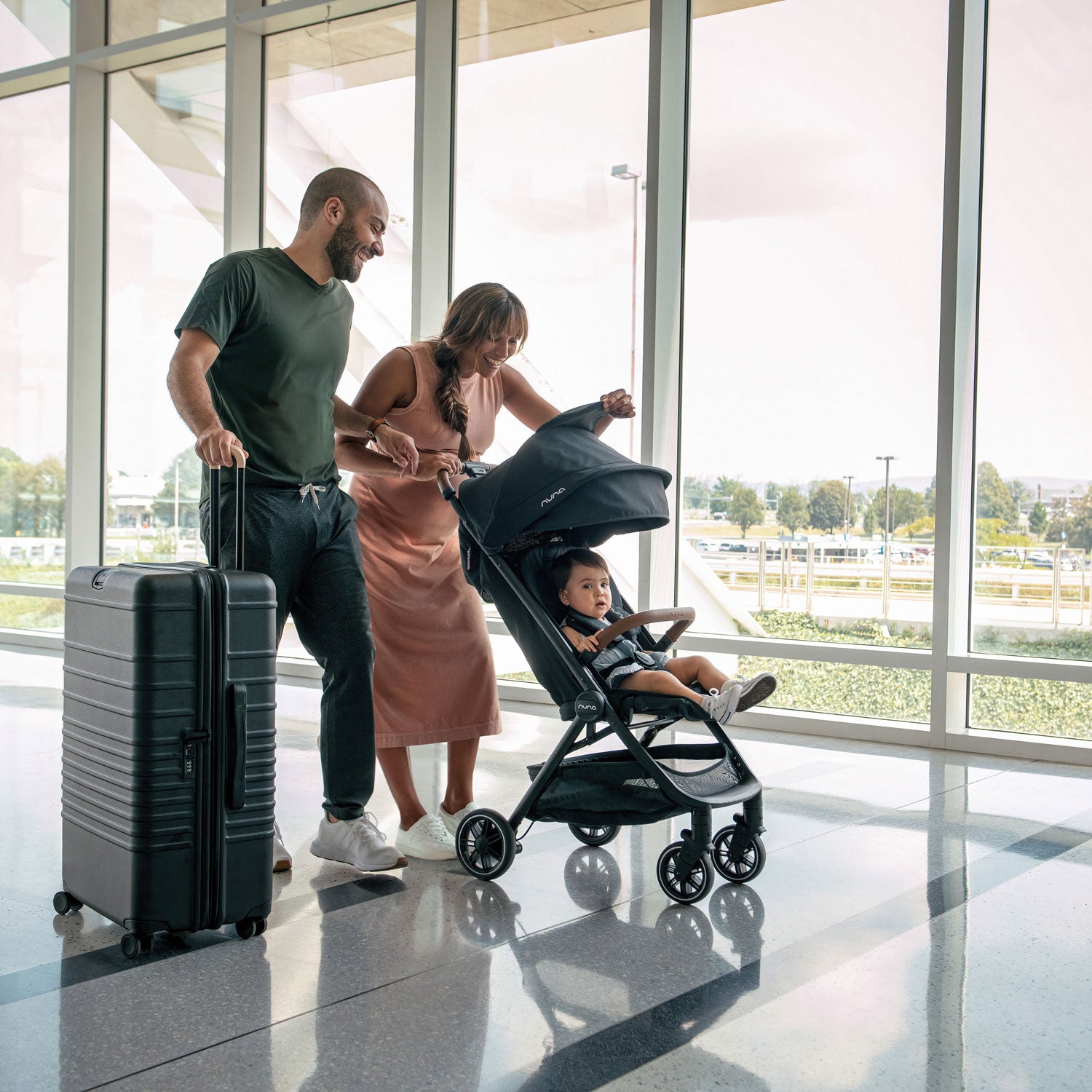 Couple pushes Nuna TRVL Stroller through airport