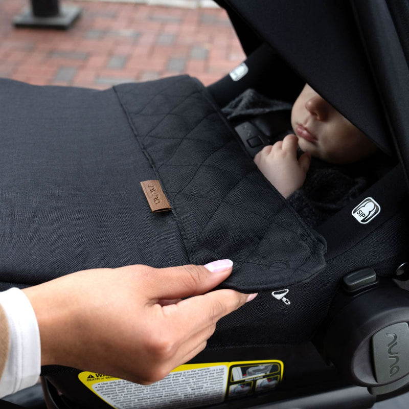 Mom attaches Nuna PIPA Lite RX Footmuff - Caviar to stroller