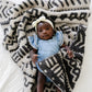 Baby girl laying in Saranoni Receiving Double-Layer Bamboni Blanket - Mudcloth