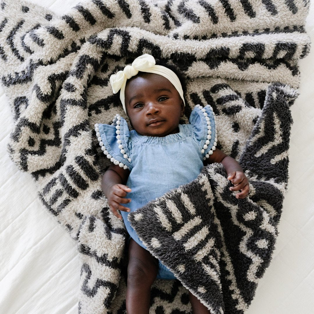 Baby girl laying in Saranoni Receiving Double-Layer Bamboni Blanket - Mudcloth