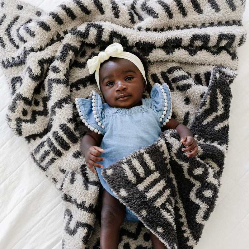 Baby girl laying in Saranoni Receiving Double-Layer Bamboni Blanket - Mudcloth